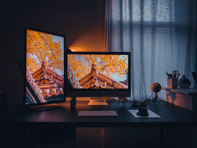 A desktop and a display showing different crops of the same photograph in a room.
