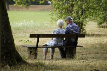 Older couple setting on bench at park