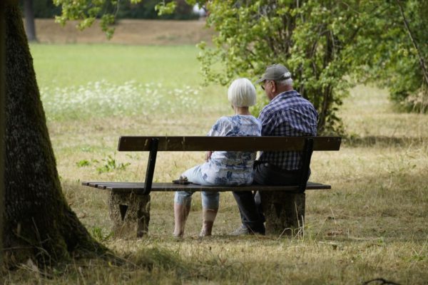Older couple setting on bench at park